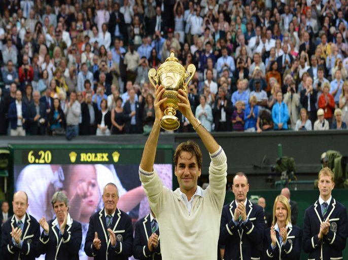 JR3683 - Wimbledon, Greater London, UNITED KINGDOM : Switzerland's Roger Federer celebrates with the trophy after his men's singles final victory over Britain's Andy Murray on day 13 of the 2012 Wimbledon Championships tennis tournament at the All England Tennis Club in Wimbledon, southwest London, on July 8, 2012. Federer won the match 4-6, 7-5, 6-3, 6-4. AFP PHOTO/ LEON NEAL RESTRICTED TO EDITORIAL USE