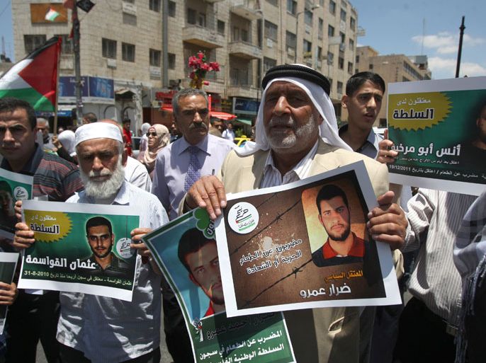 Palestinian supporters of the Islamic militant movement of Hamas, hold pictures of their relatives jailed in Palestinian authority prisons as they protest close to president Mahmud Abbas' headquarters, in the West Bank city of Ramallah, on July 4 2012. The protesters are demanding the release of their jailed relatives. AFP