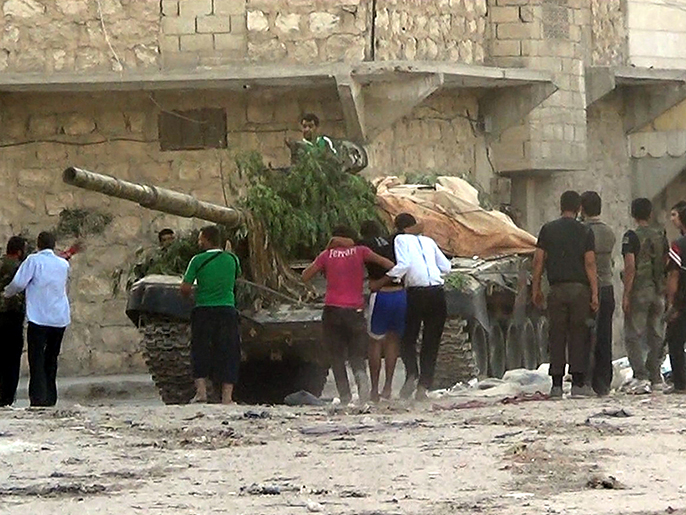 سوريون يحاولون إخفاء دبابة أعطبوها (الأوروبية-أرشيف)