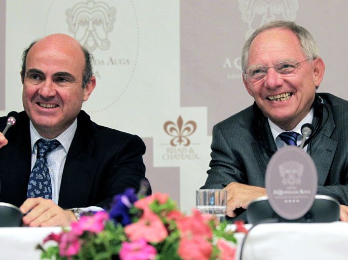 epa03201566 Spanish minister of Econmy, Luis de Guindos (L), and German Finance Minister Wolfgang Schaeuble (R), smile during a press conference at the Economic Forum organized by the Adenauer Foundation in Santiago de Compostela, northwestern Spain, 30 April 2012. EPA/LAVANDEIRA Jr.