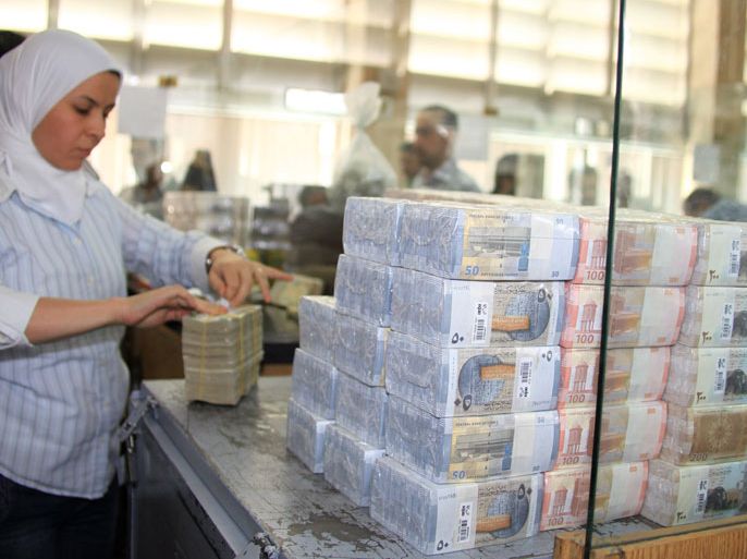 epa02262779 A bank official packs up the three new Syrian banknotes, 50, 100, 200 pounds, which have been put into circulation by the Central Bank of Syria on 27 July 2010 in Damascus, Syria. The new denominations will be used along with currently circulated notes. The newly-designed banknotes have different colors and bear high technical merits and security guarantees to resist counterfeiting. They also bear different shapes on their both sides. EPA/YOUSSEF BADAWI