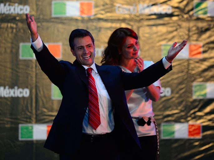 Mexico City, -, MEXICO : The Mexican presidential candidate for the Institutional Revolutionary Party (PRI), Enrique Peña Nieto (L), accompanied by his wife Angelica Rivera, celebrates after learning the first official results of the presidential election, at the party's headquarters in Mexico City on July 1, 2012. Peña Nieto, the new face of the party that governed Mexico for seven decades, won Sunday's presidential election, according to first official results by the independent Federal Electoral Institute (IFE). Peña Nieto had around 38 percent of the vote against around 31 percent for his nearest rival, leftist Lopez Obrador from the Party of the Democratic Revolution (PRD), according to the early count. AFP PHOTO/Alfredo ESTRELLA