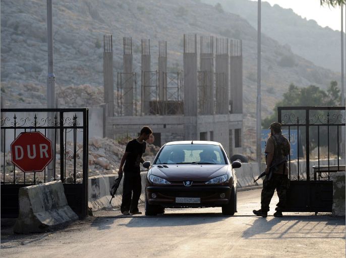 Gunmen who said they are members of a Jihadist group called Shura Taliban Islam open the Bab al-Hawa border gate between Turkey and Syria on July 21, 2012. Heavy clashes raged between Syrian troops and rebels, with at least 24 people killed nationwide, as the clock ticked down on a 30-day "final" extension of a troubled UN observer mission. AFP PHOTO / BULENT KILIC