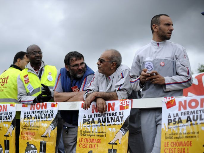 epa03304539 PSA workers stand outside the carmaker 's site in Aulnay, near Paris, France, 12 July 2012. French carmaker Peugeot Citroen has set out plans to cut 8,000 jobs and would stop production of the Aulnay plant near Paris, which employs 3,000 workers. EPA/YOAN VALAT
