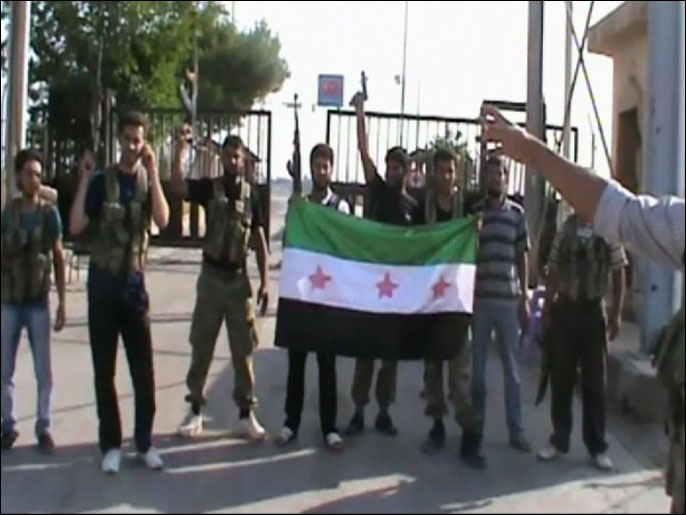 أفراد من الجيش السوري الحر بعد سيطرتهم على معبر حدودي مع تركيا (الجزيرة)