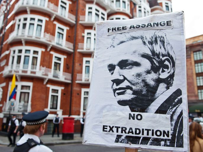 A sign showing a portrait of WikiLeaks founder Julian Assange is held by a supporter outside the Ecuadorian Embassy in London on August 16, 2012. Supporters of Julian Assange cheered for joy outside Ecuador's embassy in London today after the Latin American nation granted asylum to the WikiLeaks founder. After the announcement, British police beefed up their presence outside the embassy, which is next door to the famed Harrods department store, with around 30 officers and nine vans stationed around the building. AFP PHOTO / WILL OLIVER
