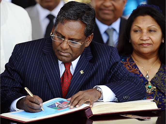 Maldives President Mohamed Waheed (L) signs the visitors' book as his wife Ilham Hussain (R) looks on during a welcome ceremony at the Bandaranaike International Airport in Katunayake on August 23,2012. The Maldives President is in Sri Lanka for a three-day official visit and will meet Sri Lankan president Mahinda Rajapaksa for talks. AFP PHOTO/ LAKRUWAN WANNIARACHCHI