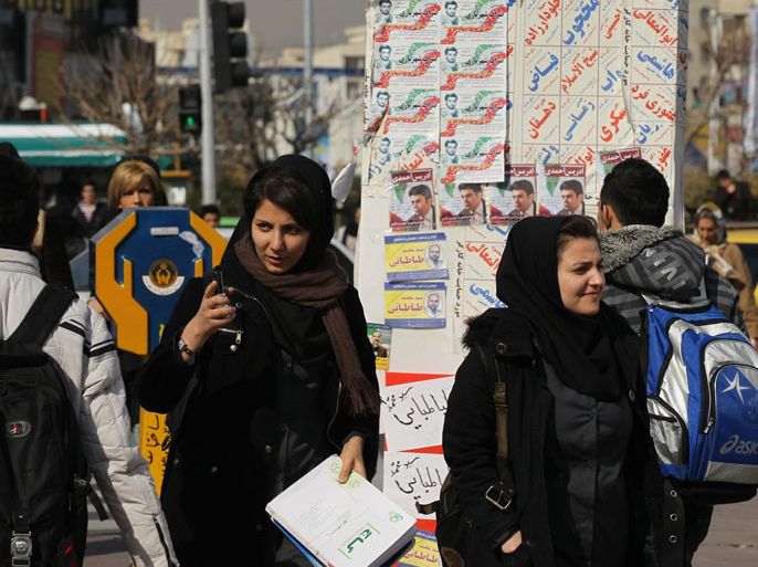 Iranian women walks past electoral posters pasted on a designated boards in the Iranian capital Tehran on February 27, 2012. Campaigning began in Iran on February 23, for parliamentary elections to take place on March 2, where an electorate of 48 million voters will chose from the 3,444 vetted candidates vying for the 290 seats in the parliament, known as the Majlis.