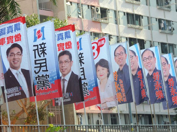 A man stands next to banners promoting candidates running the legislative elections, outside a public housing estate in Hong Kong on September 9, 2012. Hong Kong voters went to the polls in legislative elections seen as a crucial test for the Beijing-backed government, as calls for full democracy grow and disenchantment with Chinese rule surges