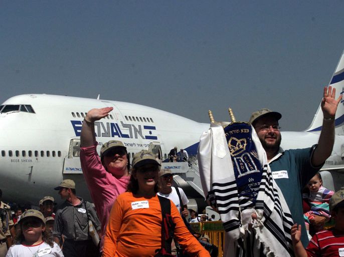 American Jewish immigrants wave their hands carrying a Tora scroll as they arrive at Ben Gurion airport near Tel Aviv, Wednesday 14 July 2004. Around 400 Jews from north America arrived to Israel as part of a programme organised by 'Nefesh Benefesh' association which is helping to more than 1500 American Jews to move to Israel during the summer of 2004. EPA/PAVEL WOLBERG