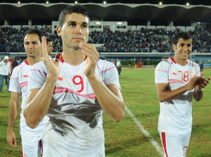 Tunisian players Zouheir Dhaouadi(L) Hamdi Harbaoui(C) and Anis Boussaidi(R) jubilate after their qualification against Sierra Leone in 2013 Africa Cup of Nations football match on October 13, 2012 in Monastir olympic stadium. AFP PHOTO / KHALIL