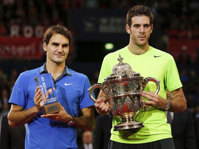 Argentina's Juan Martin Del Potro (R) poses with the trophy next to Switzerland's Roger Federer after winning his final match at the Swiss Indoors ATP tennis tournament on October 28, 2012 in Basel. Del Potro ended a losing streak of six matches this season to world number one Roger Federer in beating him in the final of the ATP tournament 6-4, 6-7 (5/7), 7-6 (7/3). AFP PHOTO / FABRICE COFFRINI
