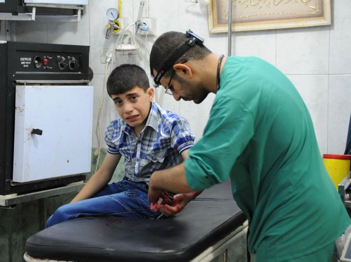 طبيب يعالج طفلا مصابا بشظية في مشفى دار الشفاء بحي الشعار بحلب
