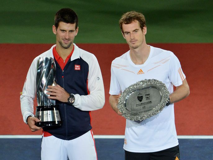 Novak Djokovic of Serbia (L) holds the winners trophy after defeating Andy Murray of Britain (R) during their finals match at the Shanghai Masters tennis tournament in Shanghai on October 14, 2012. Djokovic avenged his US Open defeat to beat Andy Murray on October 14, saving five match points to seal a stunning 5-7, 7-6 (13/11), 6-3 victory in the Shanghai Masters final. AFP PHOTO /Mark RALSTON