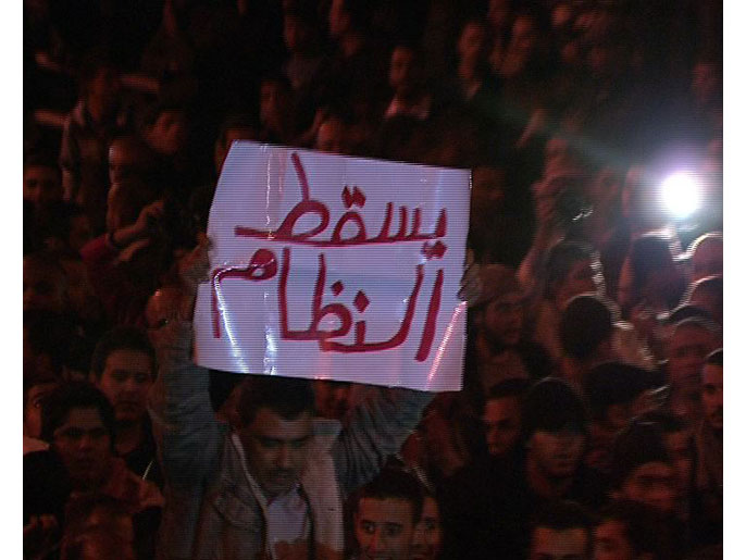 متظاهر يرفع شعار إسقاط النظام في اعتصام بالعاصمة الأردنية(الجزيرة)