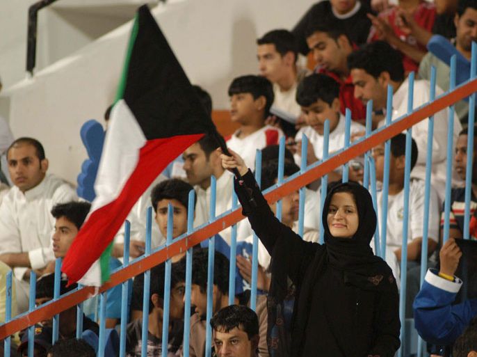epa000398253 A Kuwaiti woman waves a flag in support the Kuwaiti football team during their World Cup qualifying match against Uzbekistan in Kuwait, Friday 25 March 2005. Kuwait won the match 2:1. EPA/Raed Qutena