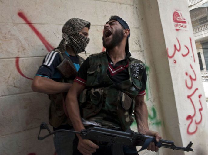 -- AFP PICTURES OF THE YEAR 2012 -- Free Syrian Army fighters take cover as they exchange fire with regime forces in the Salaheddin neighbourhood of Syria's northern city of Aleppo on August 22, 2012. At least 12 people were killed in a raid on a district of Damascus, while fighter jets and artillery pummelled the city of Aleppo and rebels claimed seizing parts of a town on the Iraqi border, a watchdog said. AFP PHOTO / JAMES LAWLER DUGGAN