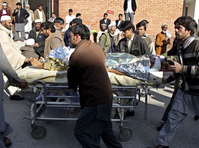 Pakistani men carry a critical injured polio vaccination worker on a stretcher to a hospital following an attack by gunmen in Peshawar on December 19, 2012. Gunmen killed three people working on a polio vaccination campaign in Pakistan on December 19, officials said, as the nationwide drive against the crippling disease suffered a third day of bloodshed. AFP PHOTO/A. MAJEED