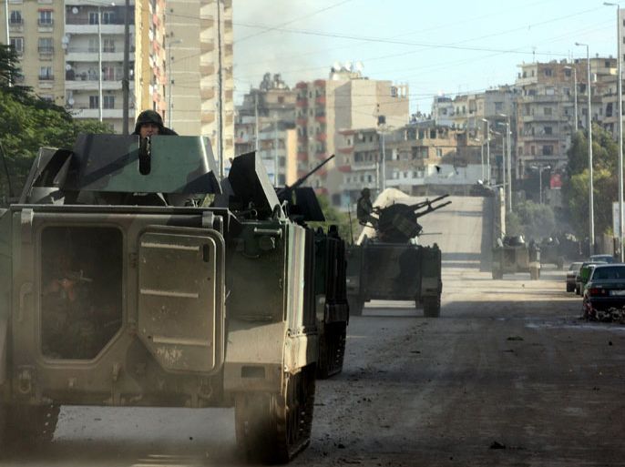 Lebanese soldiers ride in their armoured vehicle as they patrol the streets of the northern Lebanese city of Tripoli on December 5, 2012, the day after snipers shot dead two men as sectarian clashes linked to the conflict in neighbouring Syria broke out, a security official said