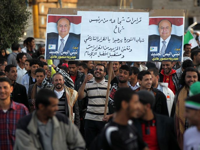 Yemeni protestors hold a placard bearing portraits of President Abdrabuh Mansur Hadi during a demonstration in Sanaa on December 20, 2012, in support of his decision to restructure Yemen's military. Hadi has dramatically restructured Yemen's military to curb the influence of those linked to toppled strongman Abdullah Ali Saleh with the strong backing of Yemen's Gulf neighbours. AFP PHOTO/ MOHAMMED HUWAIS