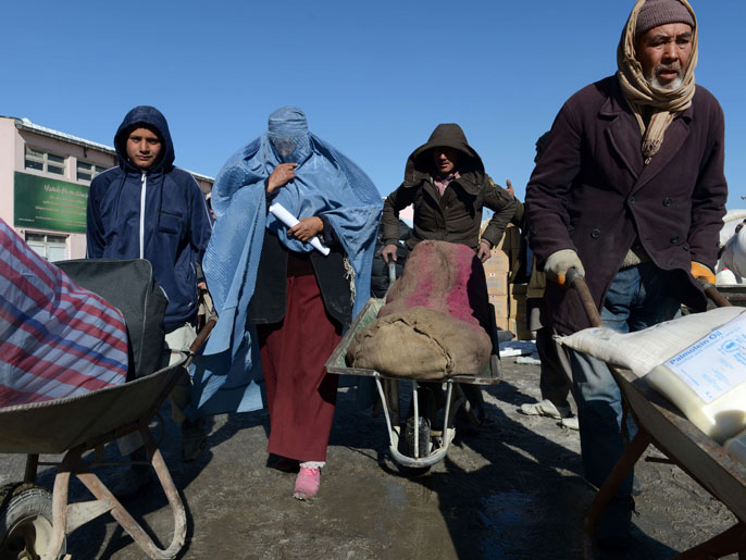 عائلات أفغانية عقب استلامها بعض المساعدات الشتوية (الفرنسية)