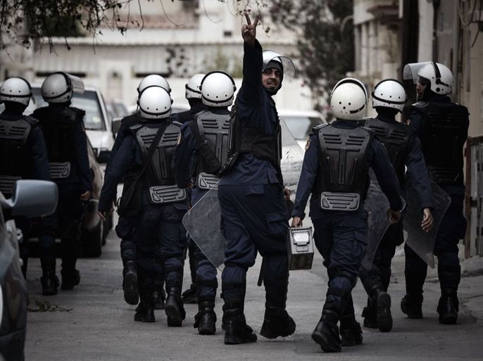 A Bahraini riot policeman makes the victory sign after riot police dispersed anti-regime protesters demonstrating against the death of a child, in the village of Daih, west of Manama, on January 30, 2013. The child, Qassim Habib Marzooq, died in hospital after developing respiratory complications and his relatives claim that his death is due to the inhalation of poisonous tear gas that riot police used during a protest in January 2013.