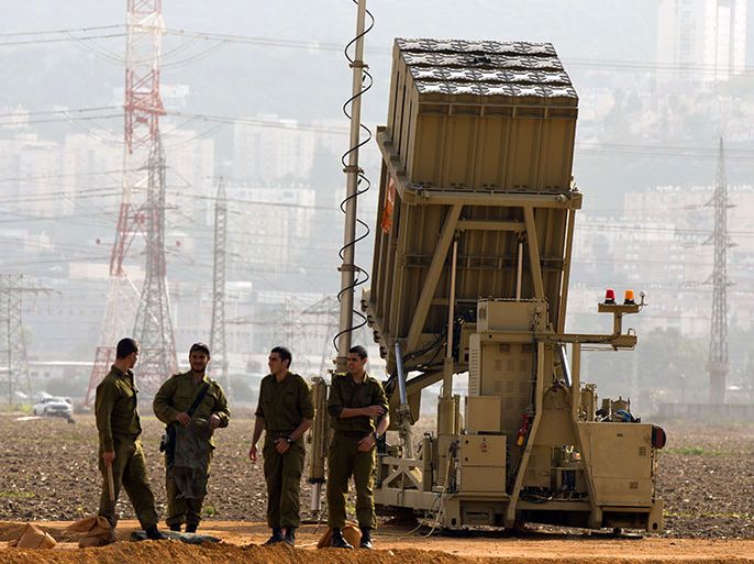 Israeli soldiers stand next to an "Iron Dome" short-range missile defence system near the northern Israeli city of Haifa on January 28, 2013. The Iron Dome defence missile system is designed to intercept and destroy incoming short-range rockets and artillery shells. Fearing that Syrian chemical weapons could fall into the hands of Islamist militants, Israel is taking diplomatic and military steps to prevent it, local media and a security source said. AFP PHOTO / JACK GUEZ