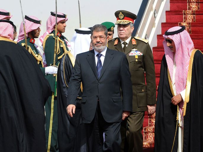 audi Emir Mohammed Bin Saad Bin Abdulaziz, acting deputy Emir of the Riyadh region (R) welcomes Egypt's President Mohamed Morsi (C) upon the latter's arrival at Riyadh airport to attend the third Arab Economic, Social and Development Summit, on January 21, 2013 in Riyadh. Saudi Arabia is hosting the two day summit aimed at relaunching regional cooperation in the face of economic challenges which were at the root of the Arab Spring uprisings. AFP PHOTO/FAYEZ NURELDINE