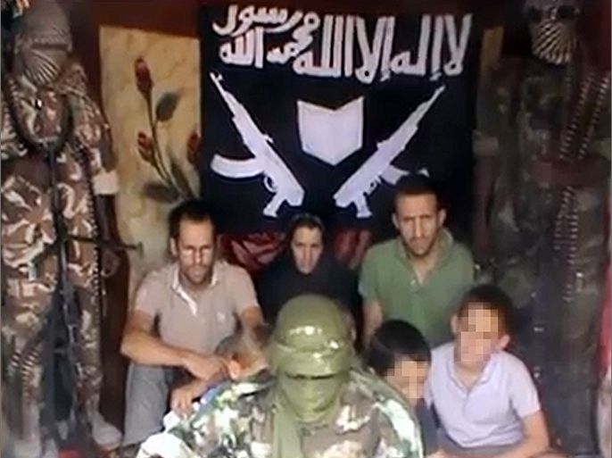 A picture grabbed on a video released by on YouTube on February 25, 2013 shows Tanguy Moulin-Fournier (L) sitting next to his wife, Albane (C, wearing a black veil), his brother Cyril, and their four children flanked by an armed man in an undisclosed place. The family -- a couple, their children aged five, eight, 10 and 12 and an uncle -- was snatched in Cameroon on February 19, 2013 by six armed suspected Islamists on three motorbikes. A video of seven kidnapped members of a French family along with their Islamist abductors appeared on YouTube on Monday, the first such images to emerge since they were taken hostages in Cameroon last week. The more than three-minute video shows the family, including four children, held in an undisclosed location, surrounded by at least three of the abductors whose faces are hidden and who claim to be from Nigerian Islamist extremist group Boko Haram. A source close to the family confirmed their identities to AFP.
