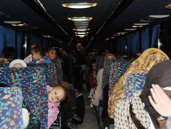 ‪لاجئون سوريون في حافلة للجيش الأردني‬ لاجئون سوريون في حافلة للجيش الأردني (الجزيرة نت)