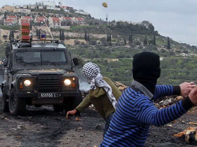 Palestinian protesters rethrow stones at israeli soldiers during clashes following a protest against the expropriation of Palestinian land by Israel on February 1, 2013 in the village of Kafr Qaddum, near Nablus, in the occupied West Bank.