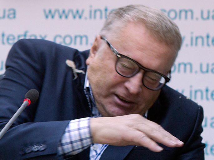 Leader of the Liberal Democratic Party of Russia (LDPR) Vladimir Zhirinovsky attempts to turn away from sauerkraut thrown by an unidentified woman during a news conference in the Ukrainian capital Kiev, January 28, 2013