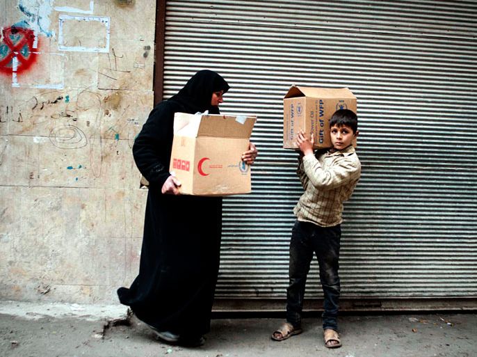 epa03591282 A Syrian woman and her child carry a box of food aid received from the local committee of Al Fardos neighbourhood, Aleppo, Syria, 19 February 2013. According to local media reports, this committe takes care of 4000 families in this area. According to activists, at least two mortar shells fell 19 February near the southern fence of the Syrian presidential palace, resulting only in material damage according to the official news agency SANA. In the northern province of Aleppo, 10 children were among at least 23 people killed after troops shelled the Jabal Badero area, hours after the government expressed readiness to hold talks with the rebels. The attacks came a day after National Reconciliation Minister Ali Haidar said his country was prepared to talk with armed opposition groups - the first time in the nearly two-year-old conflict that the government has offered to hold direct negotiations with rebels, whom it has long dismissed as "terrorists." Earlier this month, the main opposition group said it was ready for dialogue with representative of the Syrian regime, focusing on the departure of al-Assad from power. But the government said it will not accept any pre-conditions for the talks. EPA/BRUNO GALLARDO