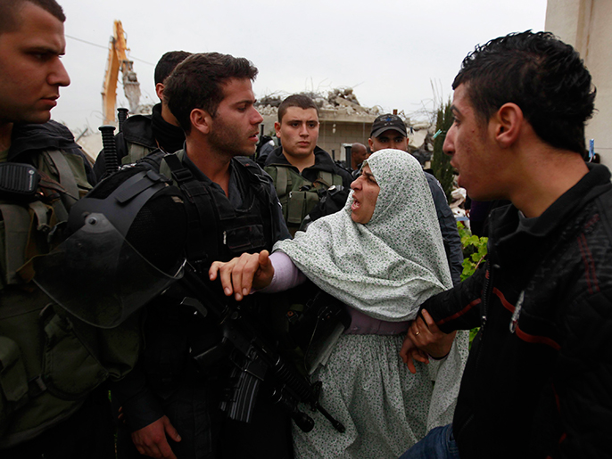 ‪فلسطينية تحاول منع الجنود الإسرائيليين من اعتقال ابنها‬ (رويترز-أرشيف)