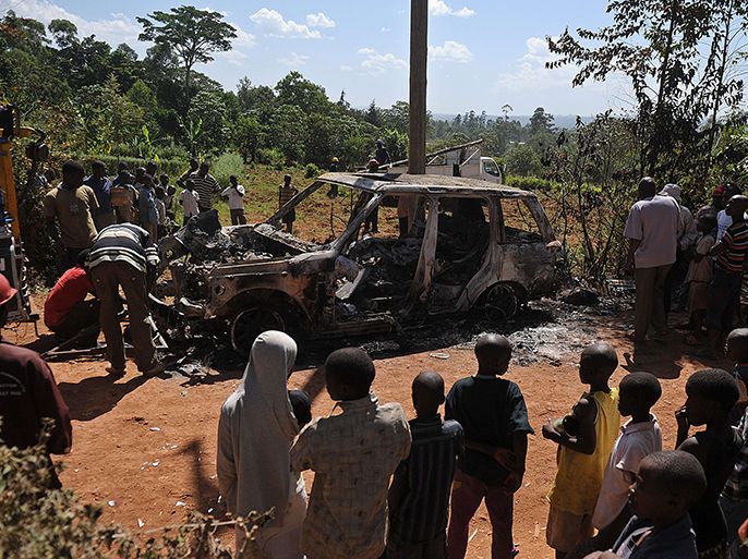 People gather around the burnt out shell of a vehicle said to belong to Shinyalu constituency parliamentary contestant, Justus Kizito Mugali, who was allegedly attacked by supporters of his rival from the area, Anami Silverse Lisamula overnight Sunday, the night leading up to Kenya's national elections on March 4, 2013 in the country's western province in Kakamega. The tense elections are seen as a crucial test for Kenya, with leaders vowing to avoid a repeat of the bloody 2007-8 post-poll violence in which over 1,100 people were killed and observers repeatedly warning of the risk of renewed conflict. AFP PHOTO/Tony KARUMBA