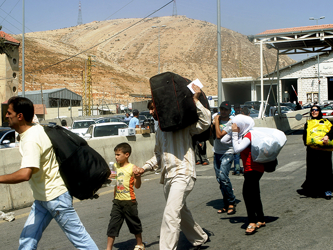 ‪(الأوروبية-أرشيف)‬ لاجئون سوريون لحظة دخولهم إلى لبنانعند نقطة المصنعة الحدودية 