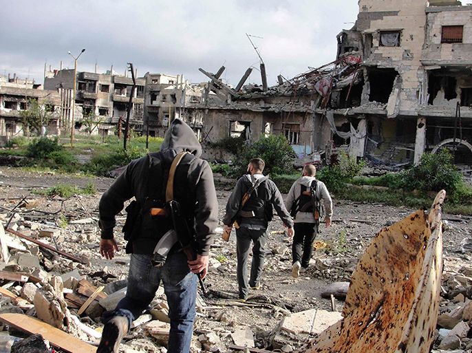 Free Syrian Army fighters walk in a destroyed neighbourhood in Homs April 5, 2013 in this picture provided by Shaam News Network. Picture taken April 5, 2013. REUTERS/Mohamed Ibrahim/Shaam News Network/Handout (SYRIA - Tags: POLITICS CIVIL UNREST CONFLICT MILITARY)