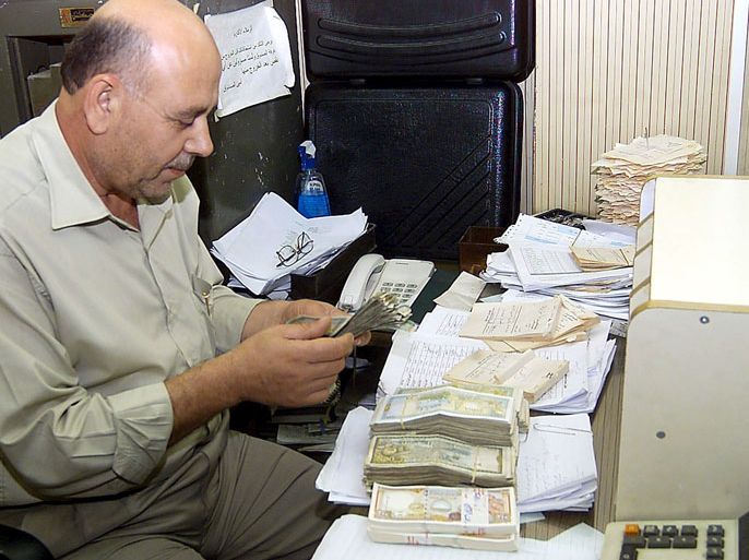 epa00831990 An official at the Central Bank of Syria counts money on Monday, Oct. 2, 2006. Syrian President Bashar al-Assad endorsed late Sunday the setting up of a stock exchange market. The stock market would be titled "Damascus Stock Market" and would enjoy a financial and administrative independence. Syrian Finance Minister Mohammad Hussein said the stock exchange aims at creating the suitable climate to facilitate the investment of capitals and give a push to economic activities as it would allow Arab and foreigners to invest in the Syrian market.(EPA Photo Youssef Badawi). EPA/YOUSSEF BADAWI