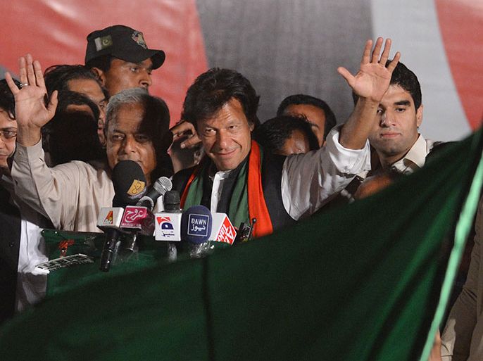 Cricket legend and chairman of Pakistan Tehreek-e-Insaaf (PTI) or Movement for Justice party, Imran Khan (C-R) waves as he arrives to address supporters during a general election campaign meeting in Taxila some 36 Kms west of Islamabad on April 29, 2013.Violence has spiked in the nuclear-armed country ahead of national elections on May 11 with at least 58 people killed in attacks on politicians and political parties since April 11, 2013. AFP PHOTO / AAMIR QURESHI
