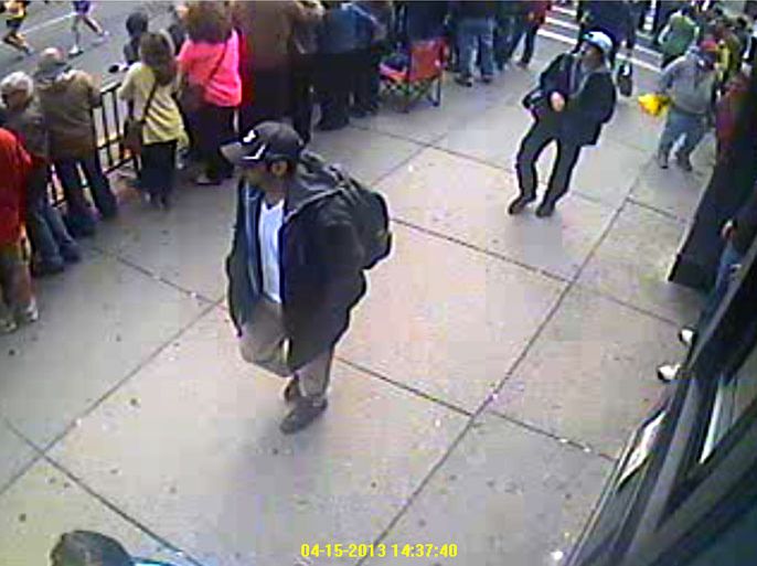 image taken from a video released by the FBI on April 18, 2013 shows two men, one with a backpack (C), and another following in white cap (rear) as they walk along the route of the Boston Marathon on April 15. The men are being sought by the FBI in connection with the marathon bombing that killed three. The US Federal Bureau of Investigation (FBI) released the photos and videos of two men sought as suspects in the Boston bombings, urging the public to help identify them.