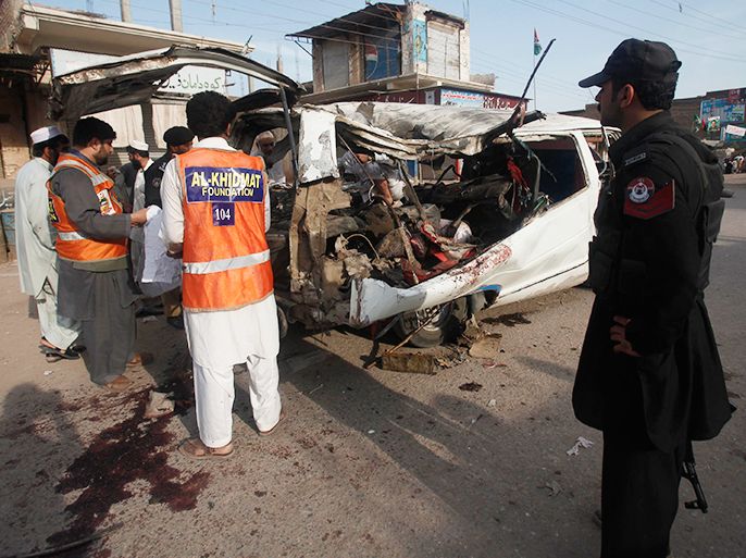 Police officials gather evidence from a damaged van at the site of a bomb blast in the Mattani Bazaar, on the outskirts of Peshawar April 13, 2013. At least nine people were killed and several others wounded when a bomb went off on Saturday, local media reported. REUTERS/Fayaz Aziz (PAKISTAN - Tags: CIVIL UNREST)