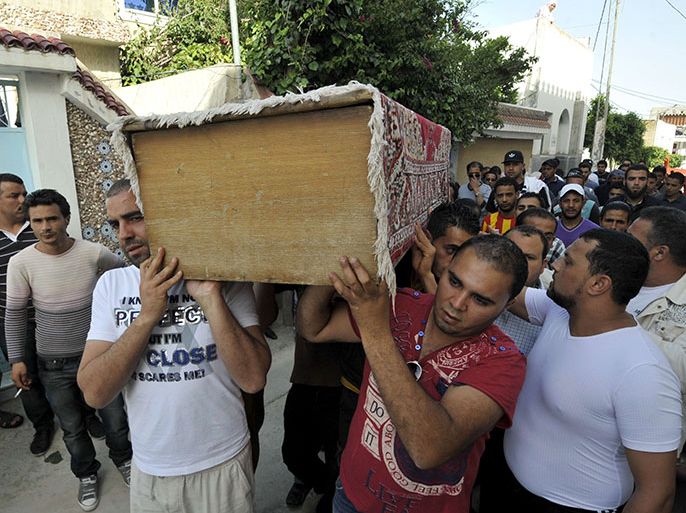 Tunisians carry the boy of a man killed during clashes between Ansar al-Sharia and police, during his funeral in Ettadhamen, a poor neighbourhood 15 kilometres (9 miles) west of Tunis, on May 20, 2013. Tunisia's Islamist premier Ali Larayedh vowed tough action against Ansar al-Sharia after bloody clashes between police and members of the radical Salafist group, hinting at a shift in government policy. AFP PHOTO/FETHI BELAID