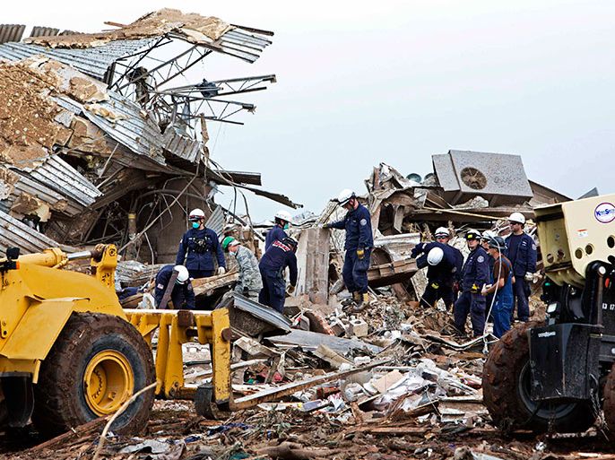 Rescue workers look through the rubble at Plaza Towers Elementary school in Moore, Oklahoma May 21, 2013 after a devastating tornado ripped through the town May 20. Officials report that he 2-mile (3-km) wide tornado has killed at least 24 people and injured more than 200 others. REUTERS/Richard Rowe (UNITED STATES - Tags: DISASTER ENVIRONMENT)