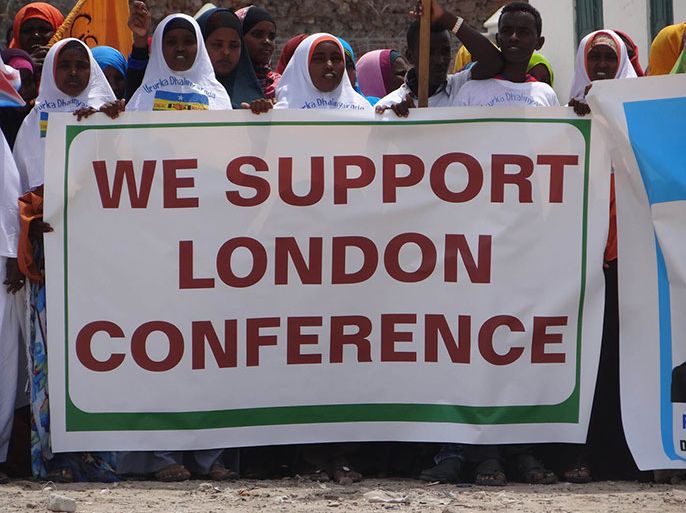 متظاهرون يحملون لافتة مكتوبة عليها عبارات مؤيدة لمؤتمر لندن