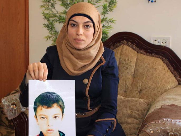 أم معتز تحمل صورة إبراهيم الذي اعتقلته قوات الاحتلال (الجزيرة نت)