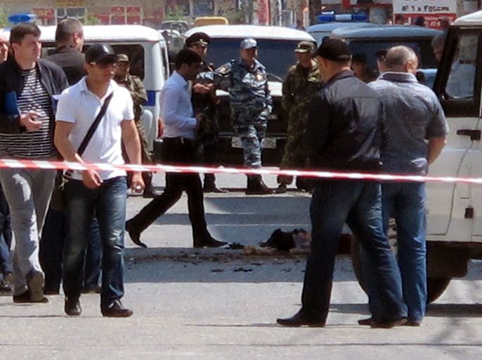 Investigators work at the site of a streetside bomb blast in Makhachkala, the capital of Russia's volatile Dagestan region, on May 1, 2013. Two teenagers were killed today in Makhachkala when they opened a box left on the street that contained an explosive device, police said. AFP PHOTO / NEWS TEAM / SULEYMAN ALIEV