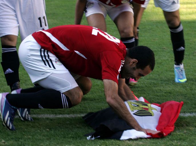 ypt's striker Aboutrika Salaire holds an Egyptian flag as he celebrates with teammates at the end of a 2014 World Cup qualifying football match against Zimbabwe on June 9, 2013 at the National Sports Stadium in Harare. Egypt won 4-2. AFP PHOTO/Jekesai Njikizana