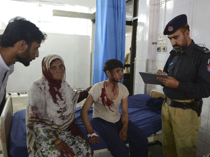 MF359 - Peshawar, -, PAKISTAN : A Pakistani policeman takes down statements from injured bomb blast victims from nearby Badaber, at a hospital in Peshawar on June 30, 2013. A car bomb aimed at a Pakistani security force convoy killed 15 people and wounded 28 others Sunday on the outskirts of the northwestern city of Peshawar, an official said. AFP PHOTO/Hasham AHMED