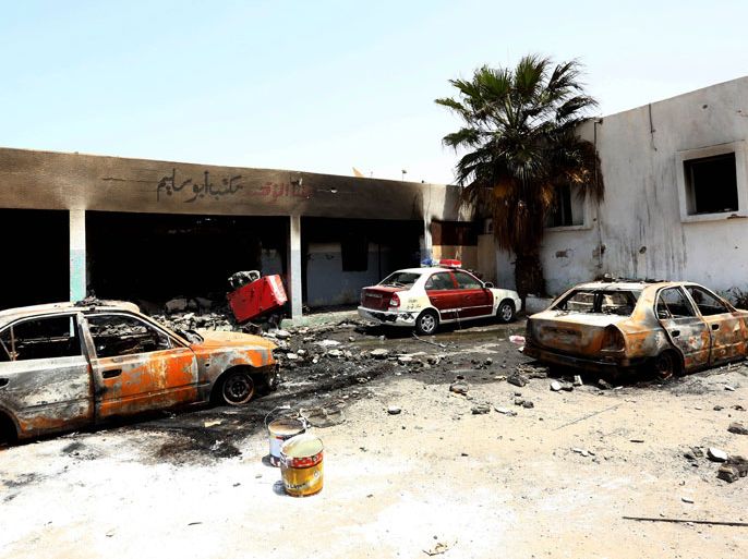 The wreckage of burnt vehicles and ransacked buildings are seen the day after deadly clashes at the Abu Salim police station on June 27, 2013 in Tripoli. Tension was palpable in the Libyan capital today, a day after deadly fighting broke out between groups of ex-rebels, highlighting the country's continuing insecurity nearly two years after dictator Moamer Kadhafi fell. AFP PHOTO/MAHMUD TURKIA