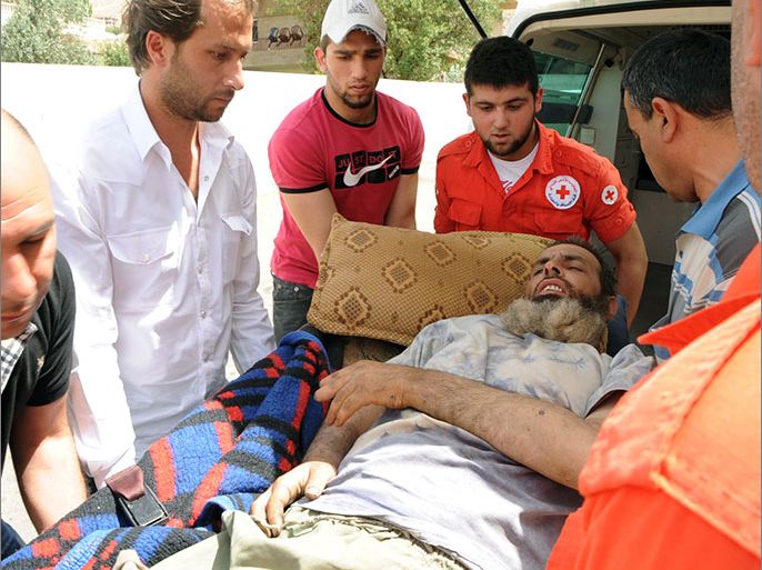 Lebanese Red Cross volunteers use a stretcher to move a Syrian man, who was wounded in the nearby Syrian city of Qusayr, from an ambulance upon their arrival at an hospital on June 8, 2013 in the city of Shtora in the Lebanese Bekaa Valley as Red Cross launched an operation to evacuate wounded people from Syria. Qusayr fell on June 5, 2013 to regime control after a nearly three-week assault by troops and Hezbollah, in the clearest sign yet of the Lebanese Shiite group's commitment to the Assad regime. AFP PHOTO STR